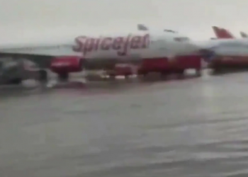 Rain fills the forecourt of the Delhi airport, and planes are delayed as a result of the inclement weather