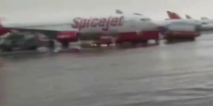 Rain fills the forecourt of the Delhi airport, and planes are delayed as a result of the inclement weather